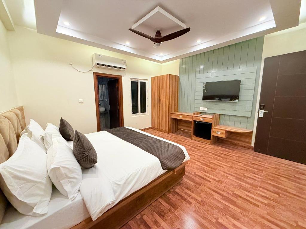 大诺伊达The Prominence Hotel Greater Noida的一间带大床和电视的卧室