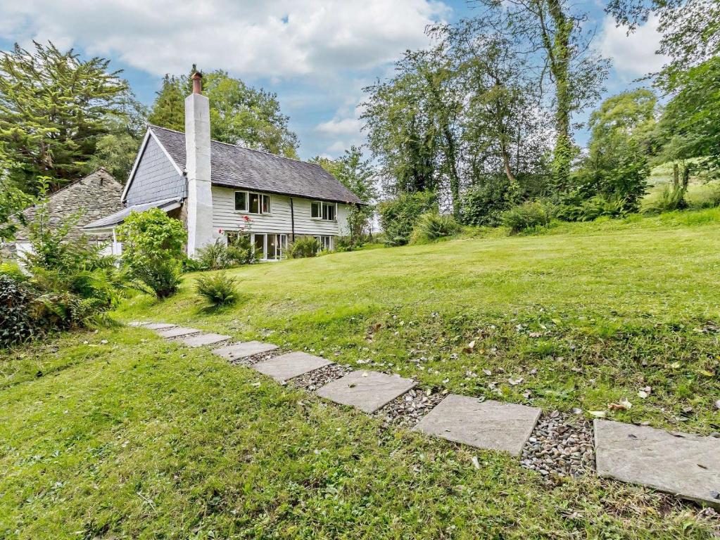 a house with a stone path in front of a yard at 3 Bed in Machynlleth 93083 in Cemmaes