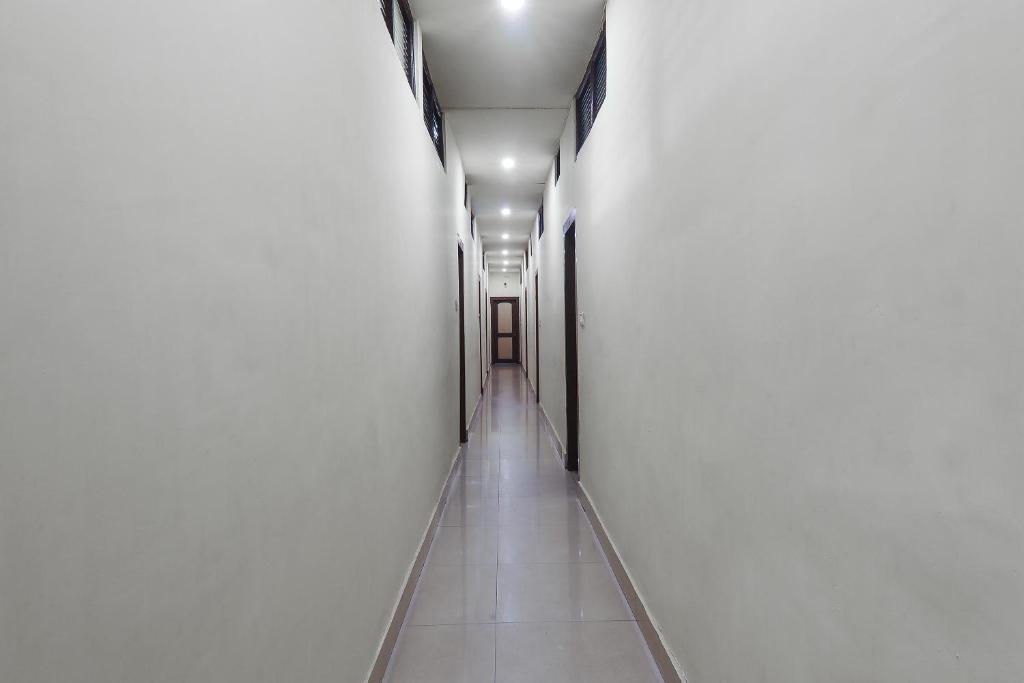 a hallway of a building with white walls and a long corridor at Hotel O Golden Peak in Shillong