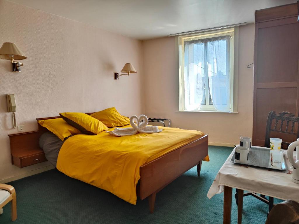a bedroom with a yellow bed with a bow on it at Chambres D'hôtes in Bains-les-Bains