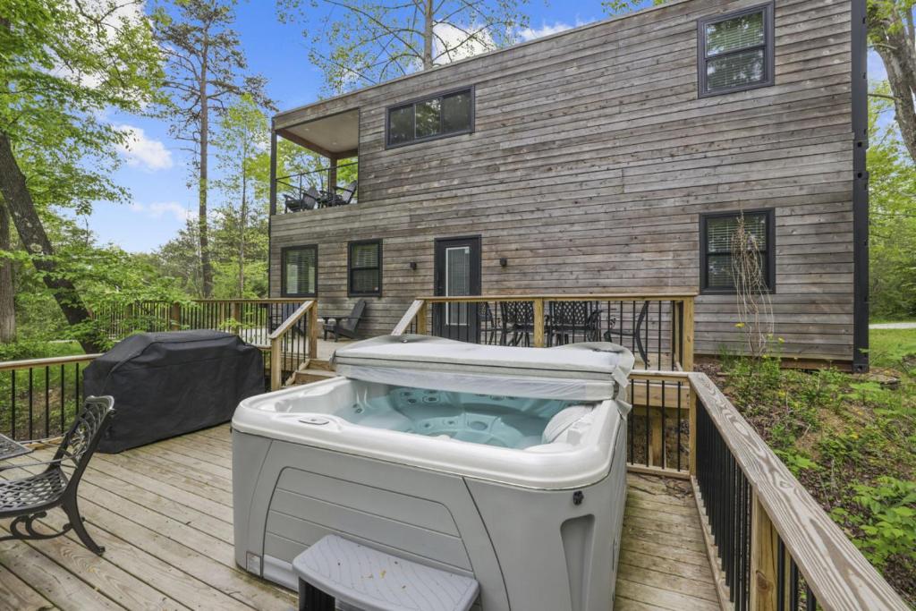 a hot tub on a deck in front of a house at Hiltop Haven The Double Stack in Rockbridge