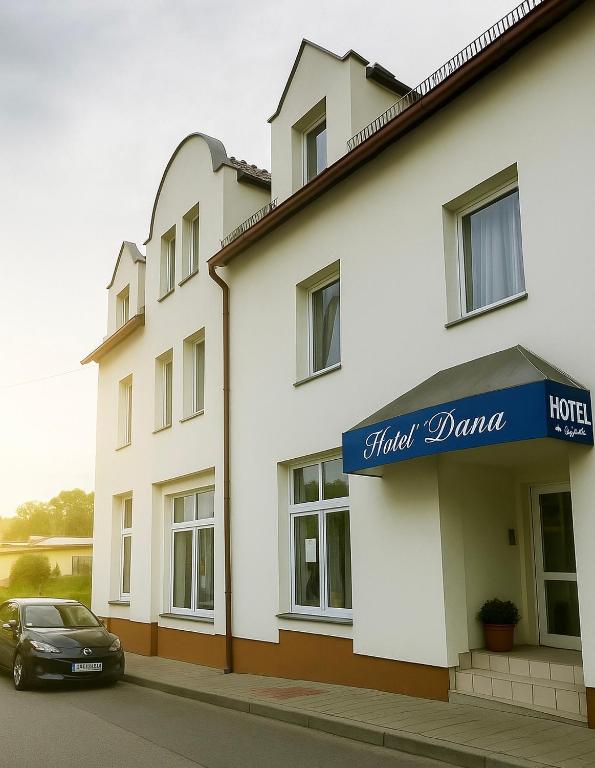 a car parked in front of a building at Hotel Dana in Bytów