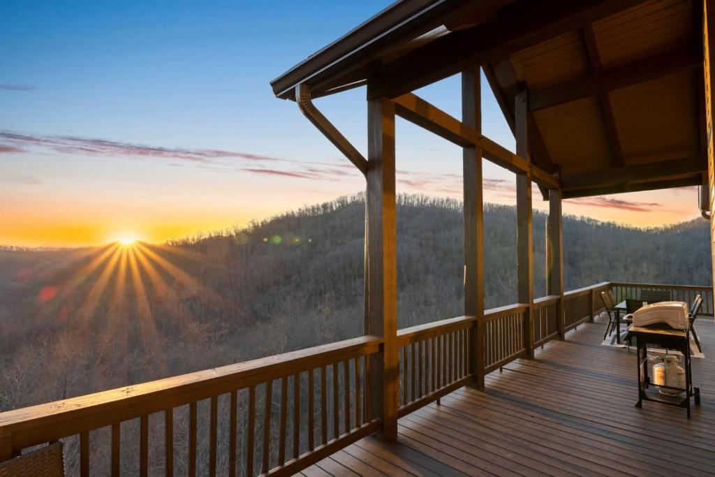 a view from the deck of a cabin with the sunset at Mountain View C - Mountain Stay, King Suite, Fireplace, and Mountain Views in Cullowhee