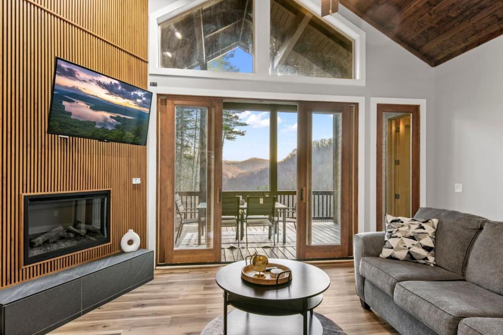 een woonkamer met een bank en een open haard bij Valley View B - Mountain Hideaway, Grill, and Sunset Views in Cullowhee