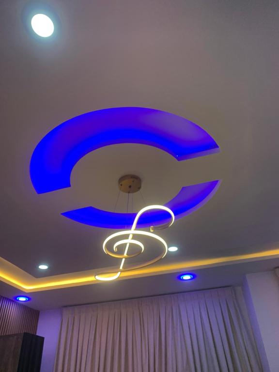 a blue chandelier on the ceiling of a room at Legacy Square Apartment in Accra