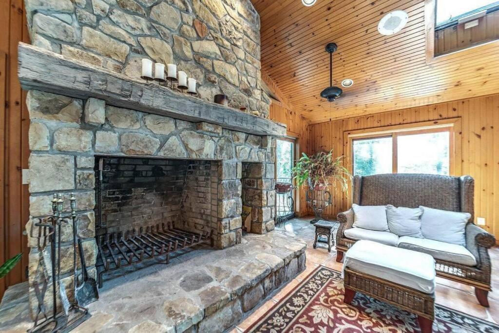 a living room with a large stone fireplace at Daisy Glen Retreat - Amazing Indoor Pool in South Bloomingville