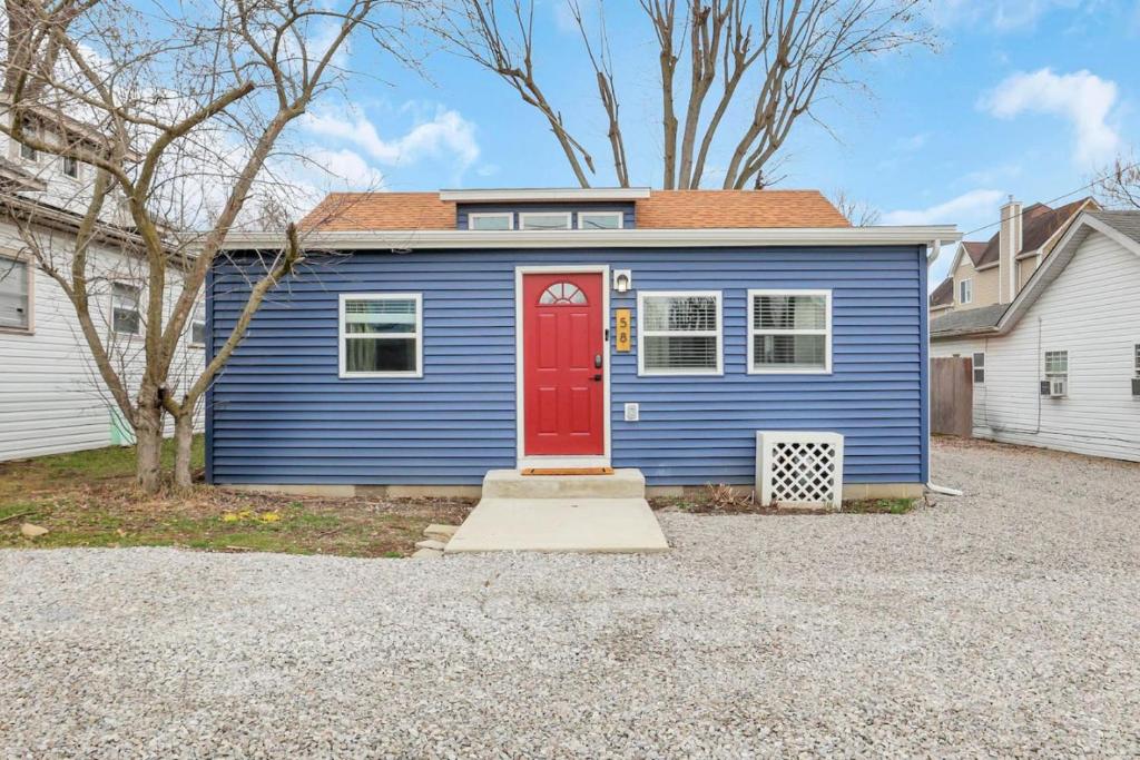 a blue house with a red door in a driveway at Gone Fishin in Buckeye Lake