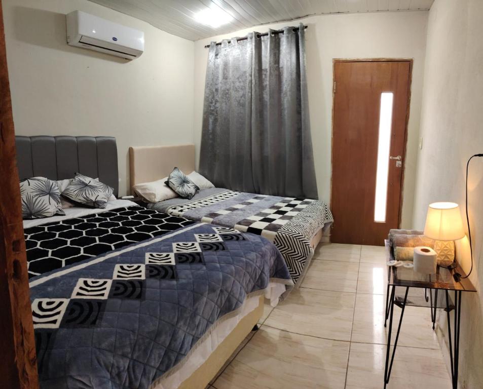 a bedroom with a bed and a table and a window at Mi Hábitat in Asuncion