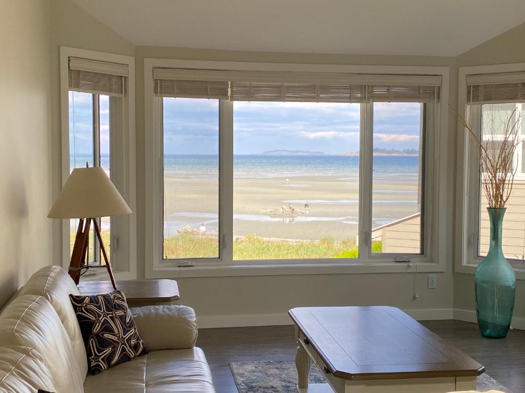 ein Wohnzimmer mit Couch und Blick aufs Meer in der Unterkunft Tanglewood 13 in Parksville