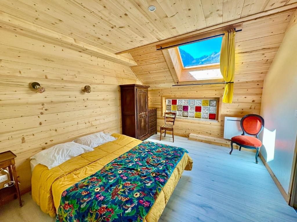 Un dormitorio con una cama en una habitación de madera. en LA SOIE, en Les Deux Alpes