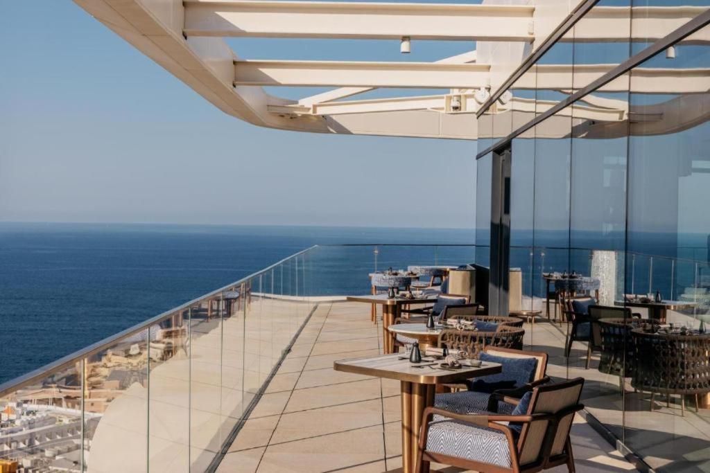 a balcony with tables and chairs and the ocean at Mercury tower Elena K 24th panoramic view apartment in St Julian's