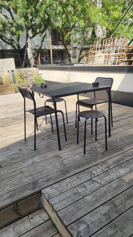 a black table and two chairs on a wooden deck at Exclusive Queen St Downtown Full House-PRIVATE PATIO in Toronto