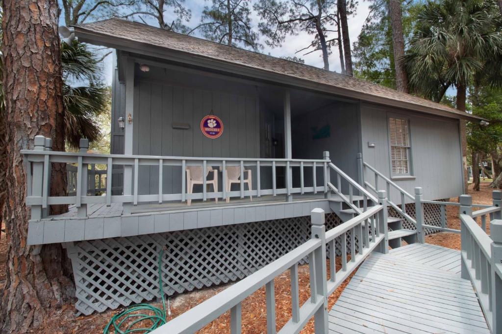 a house with a porch next to a tree at Paws4ever II in Edisto Island
