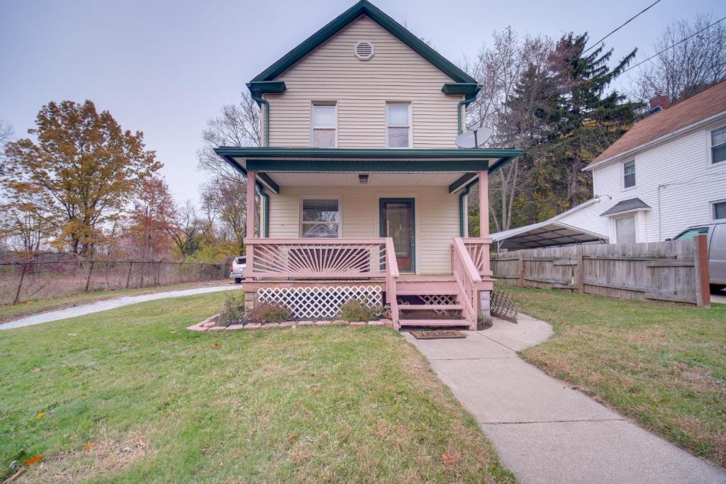 une maison avec un banc devant une cour dans l'établissement Yard, Fire Pit and Trails! Pet-Friendly Akron Home, à Akron