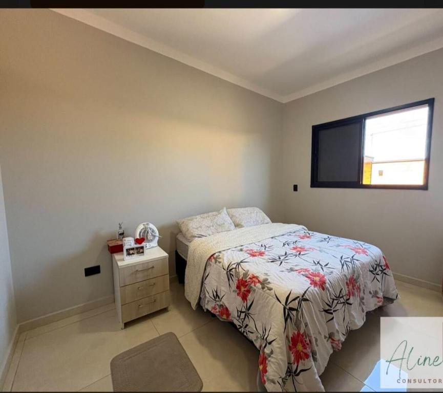 a bedroom with a bed and a television on the wall at Cantinho do Descanso in Peruíbe