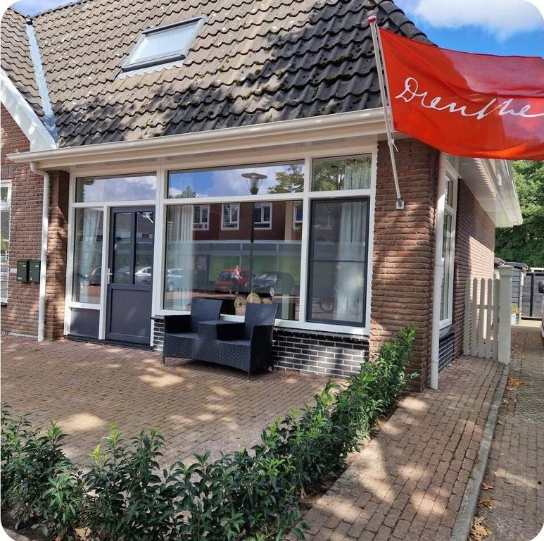 a building with a large window with chairs in it at Gastenverblijf 't Westeind in Norg