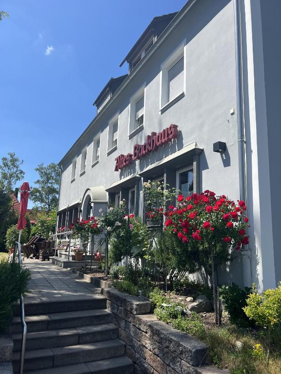 a white building with flowers in front of it at Pension Altes Backhaus in Herzogenaurach