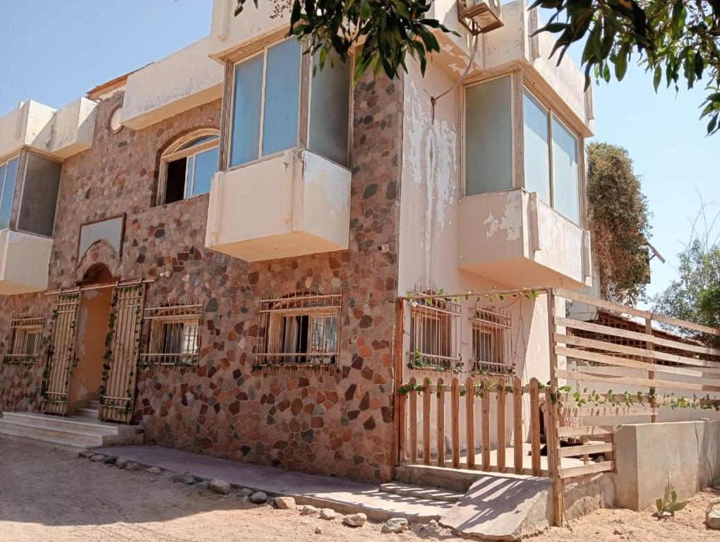un edificio antiguo con ventanas y una valla en The Lighthouse Castle III, en Dahab