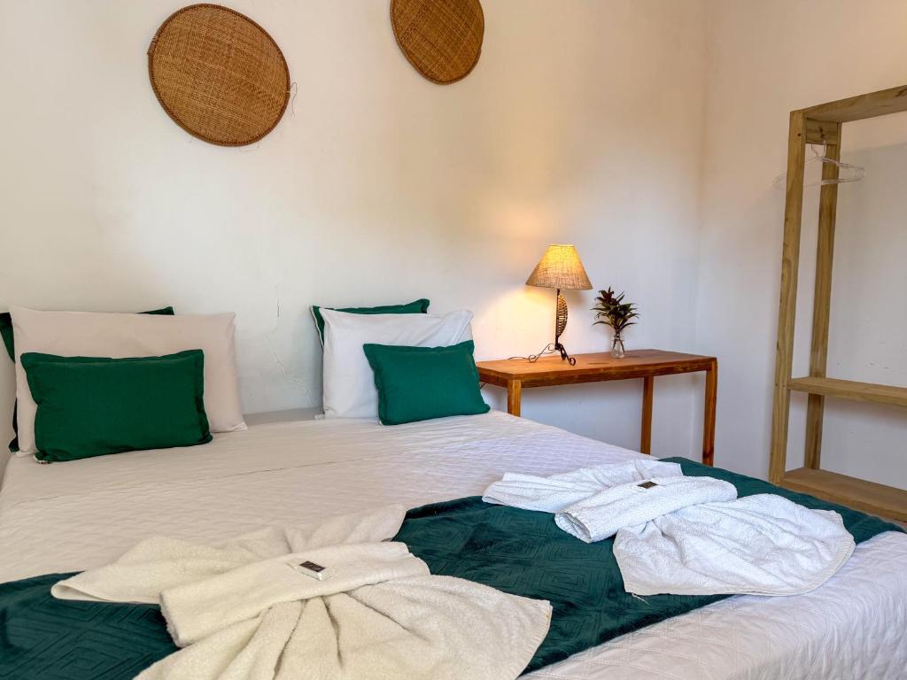 a bedroom with a bed with towels on it at Pousada João Maria in Trancoso