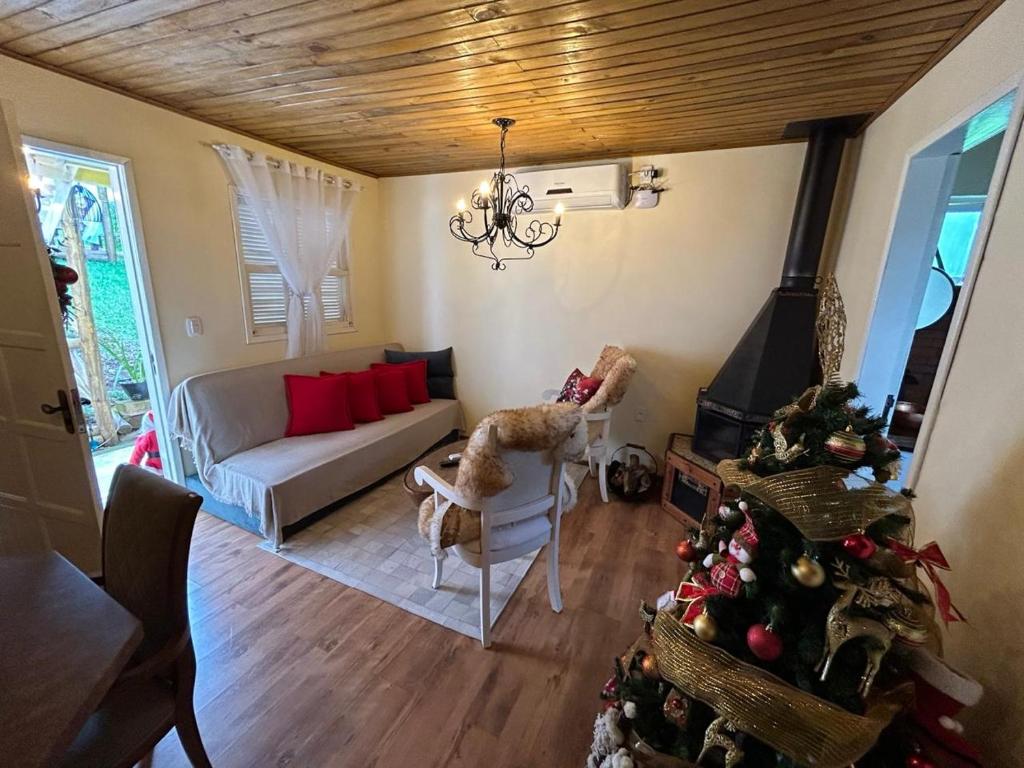 a living room with a couch and a christmas tree at Chales Gramado Exclusive in Gramado