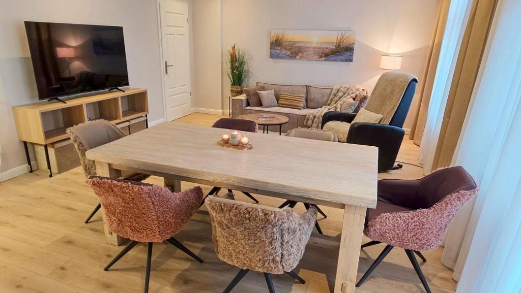 a living room with a wooden table and chairs at Amadeus Loft in Wilhelmshaven