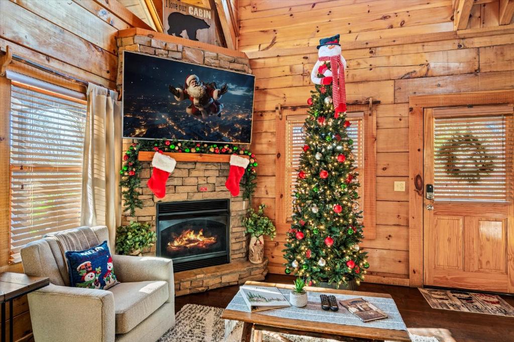 a living room with a christmas tree and a fireplace at Near Dollywood with Pool Table-Hot Tub-Fire Pit-Game Room in Pigeon Forge