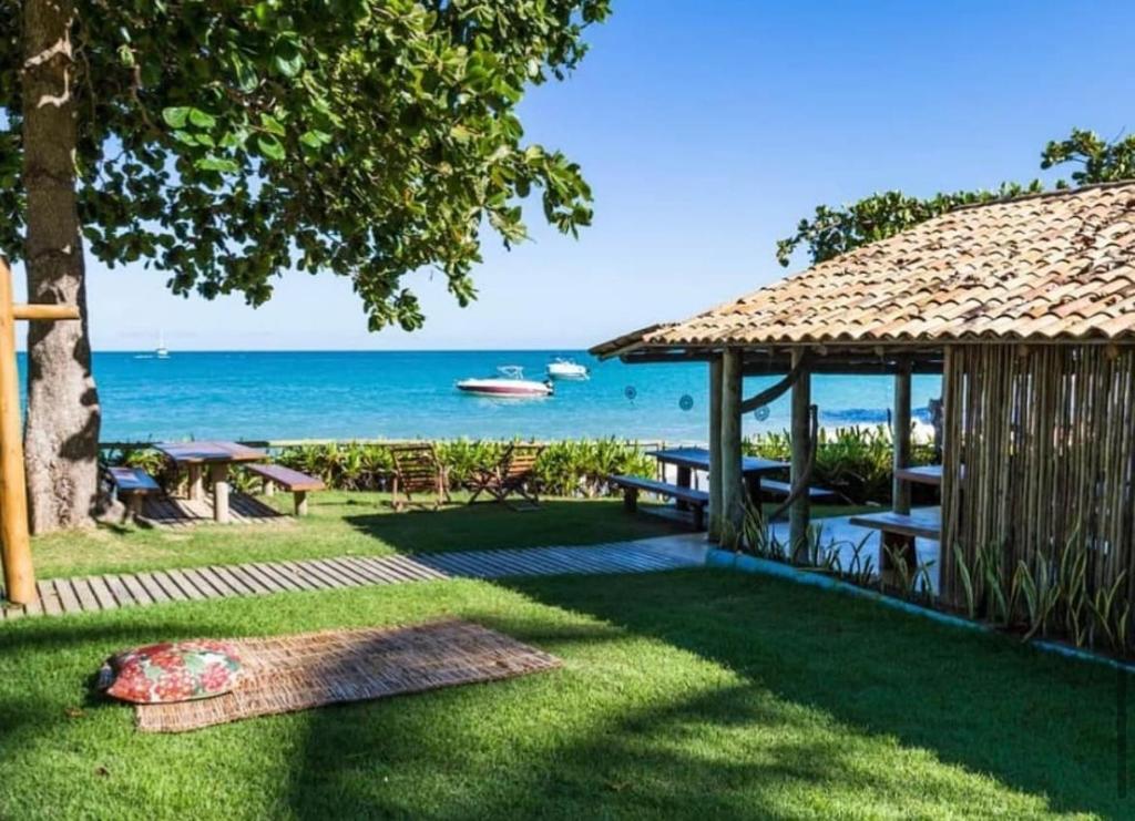 um jardim com um gazebo e o oceano em Casa Mar em Porto Seguro