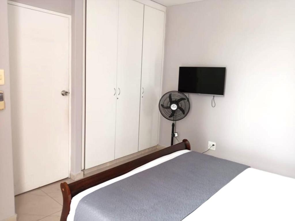 a bedroom with a bed and a fan and a tv at Durban Oceanic 82B in Durban
