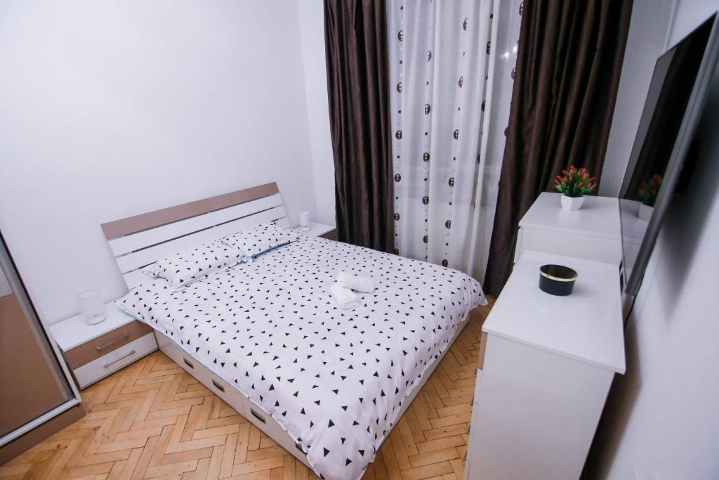ein kleines Schlafzimmer mit einem Bett und einem Nachttisch in der Unterkunft Cozy central apartament in Craiova
