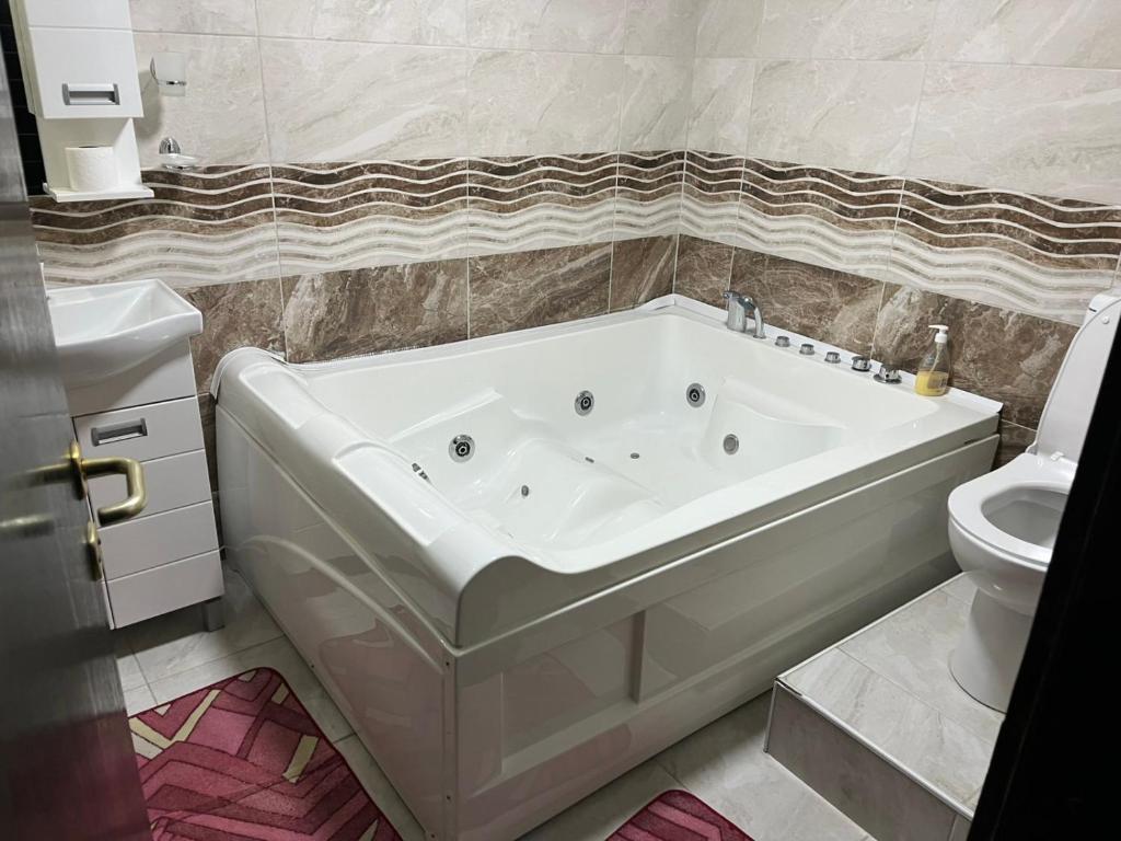 a white bath tub in a bathroom with a toilet at Konačište Lim in Čitluk