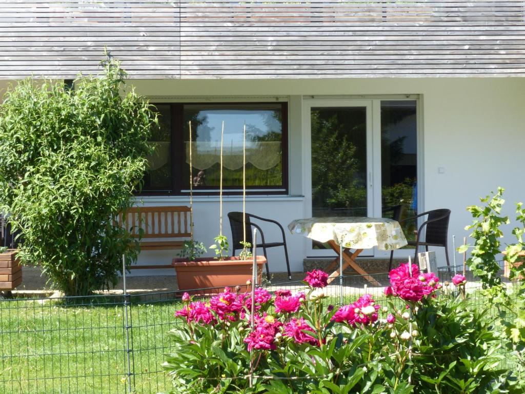 ein Haus mit einem Tisch und Blumen im Hof in der Unterkunft Ferienwohnung Paula in Sankt Johann