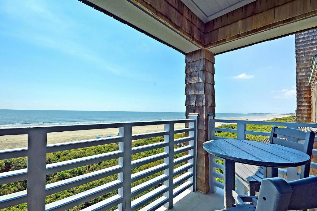 a balcony with a table and chairs and the ocean at WS4463: 4463 Windswept in Kiawah Island