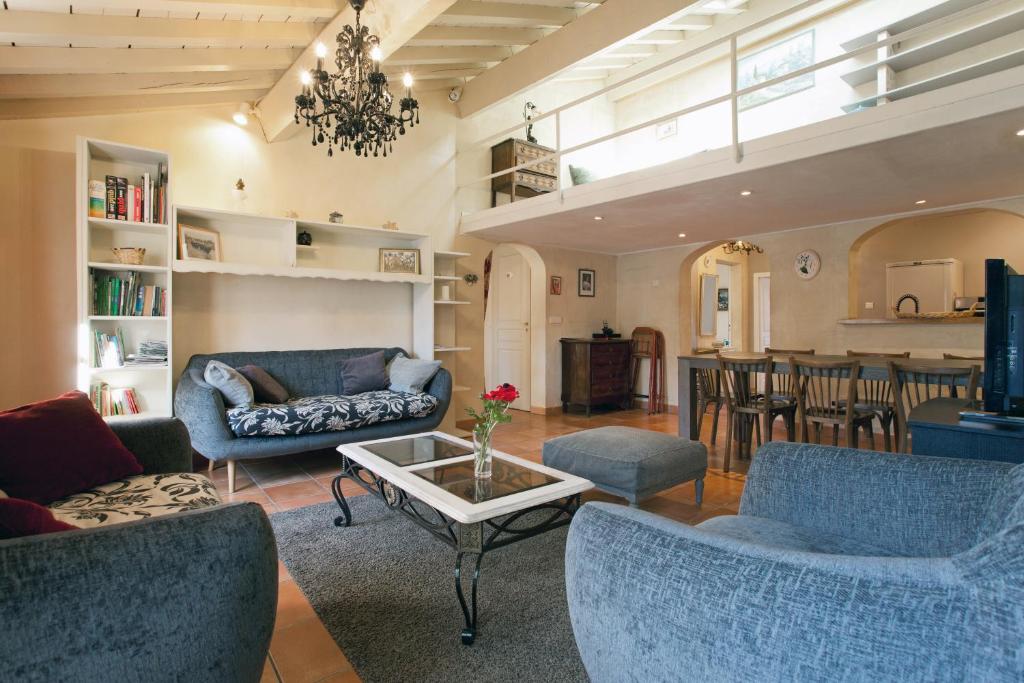 a living room with blue chairs and a table at Arelate Séjour in Arles