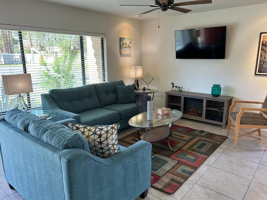 a living room with two blue couches and a tv at Rancho Mirage Gem! 90 day-bookings only in Rancho Mirage