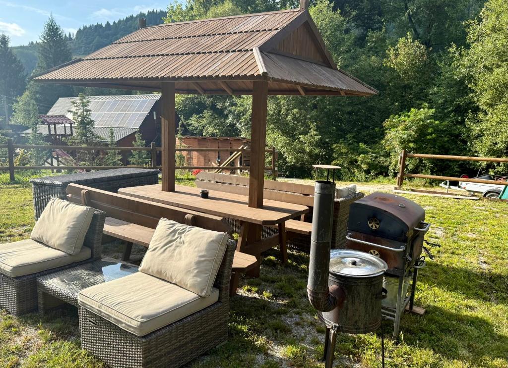 a gazebo with a picnic table and a grill at Jánošíkův pramen - celá horská wellness chata in Zázrivá