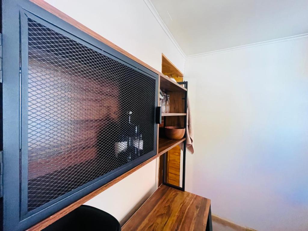 Cette chambre dispose d'une grande télévision et d'une table en bois. dans l'établissement Cabañas San Pedro de Atacama 2, à San Pedro de Atacama