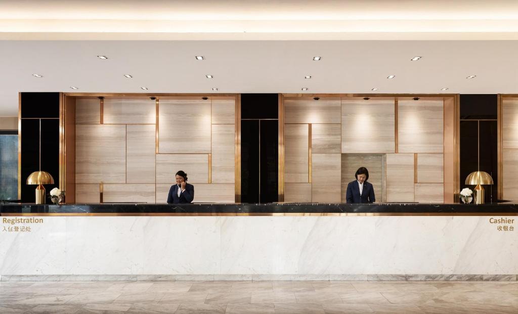 The marble reception counter with separate registration and cashier stations.