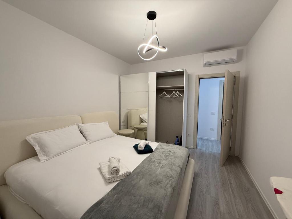 een slaapkamer met een groot wit bed en een plafondventilator bij Modern 2BR Near City Ring & Main Road Access in Tirana