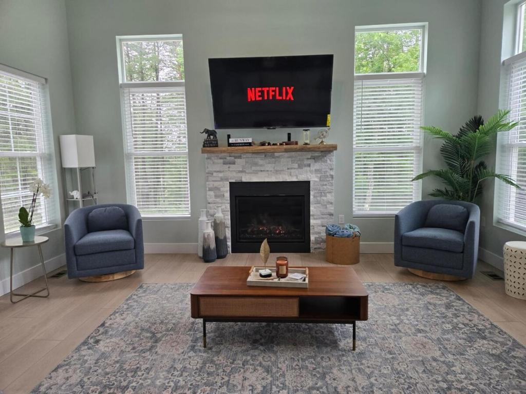a living room with a tv above a fireplace at The Backwoods Paradise in Logan