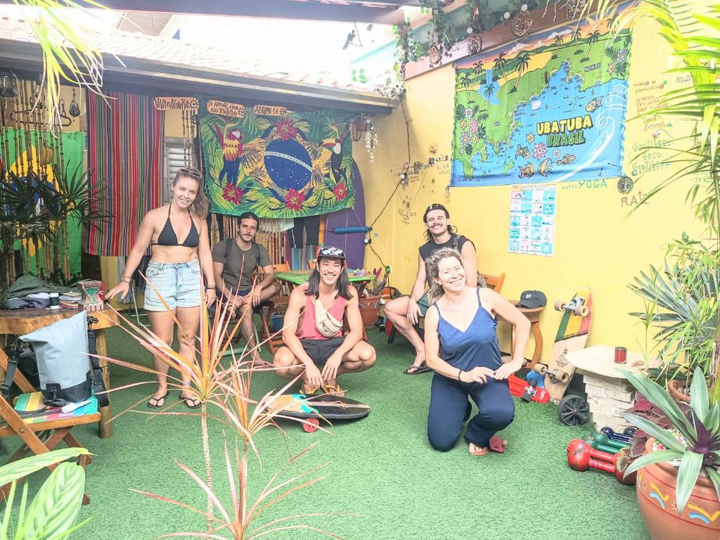 a group of people posing in a room with plants at Ubatuba Wild Surf House in Ubatuba