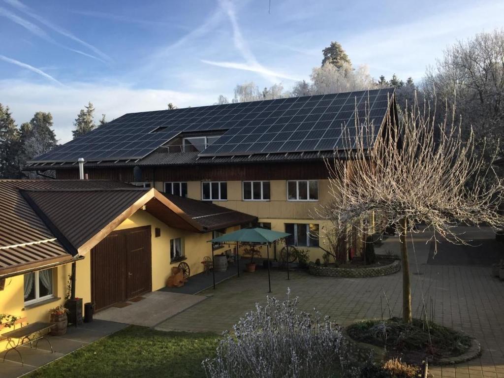 una casa con paneles solares encima en Rehalp Westen, en Bischofszell