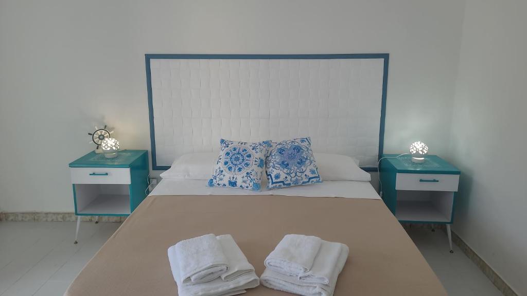 ein Bett mit zwei Nachttischen und Handtüchern darauf in der Unterkunft Casa Marigé in San Nicola Arcella