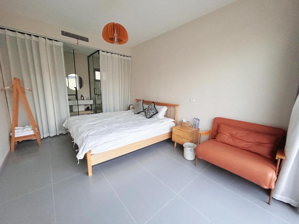 ein Schlafzimmer mit einem Bett und einer roten Couch in der Unterkunft Sanmo Nanshan Boutique Homestay in Henanzhai