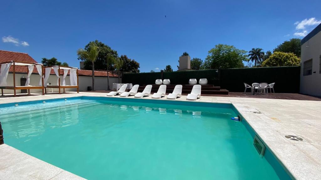 ein Swimmingpool mit Liegestühlen und ein Swimmingpool in der Unterkunft Astoria in Villa Carlos Paz