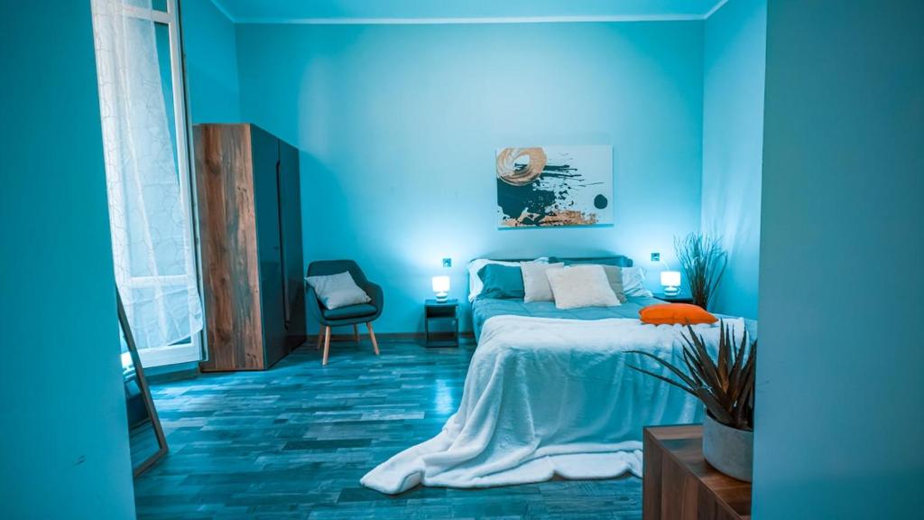 Un dormitorio azul con una cama y una pared azul. en Spacious and bright house in the center - parking, en Verona