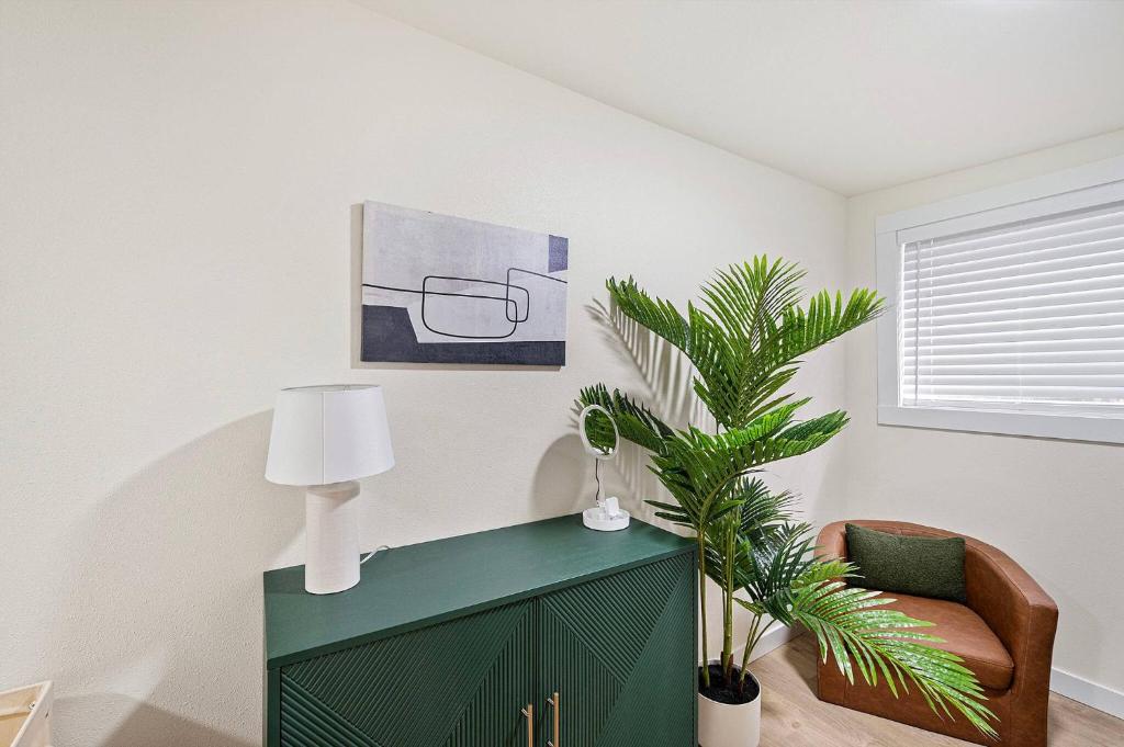 un salon avec une armoire verte et une plante dans l'établissement Juanita Bay Cottages B2, à Kirkland