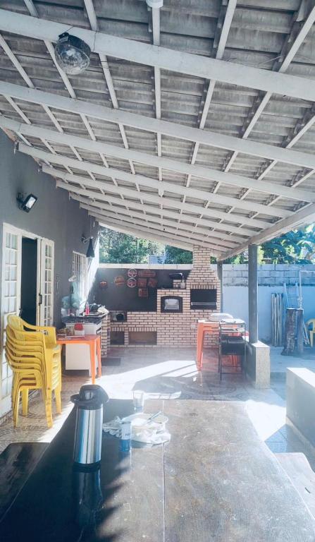 a patio with a table and chairs and a fireplace at Rancho Carvalho in Alexânia