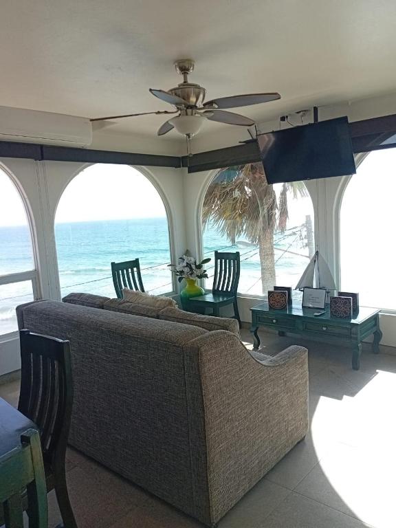 a living room with a couch and a view of the ocean at Casa Mar Verde - Oceanfront Penthouse - Pool & Jacuzzi in Primo Tapia