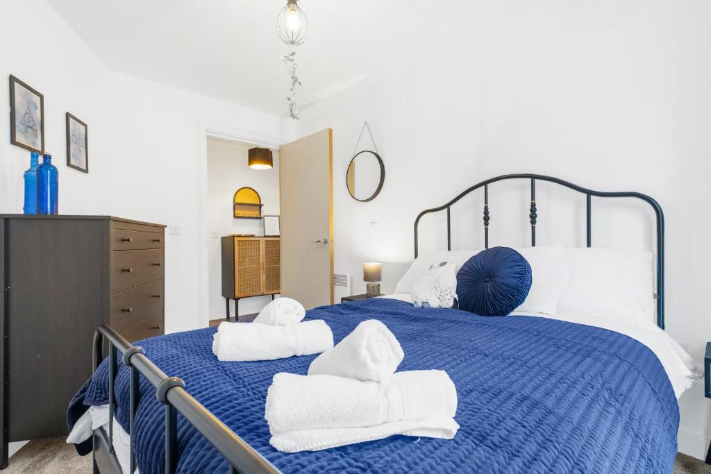 a bedroom with a blue bed with towels on it at Luxury 2Bed Spacious Apartment- City Centre- Free Parking in Birmingham