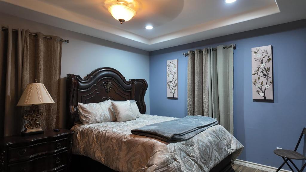 麦卡伦Spacious 4BR 3Baths Near Airport and La Plaza Mall的一间拥有蓝色墙壁的卧室、一张床和一盏灯